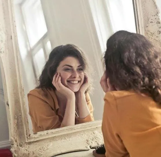 coaching-emocional-mujer-sonriendo-frente-a-espejo